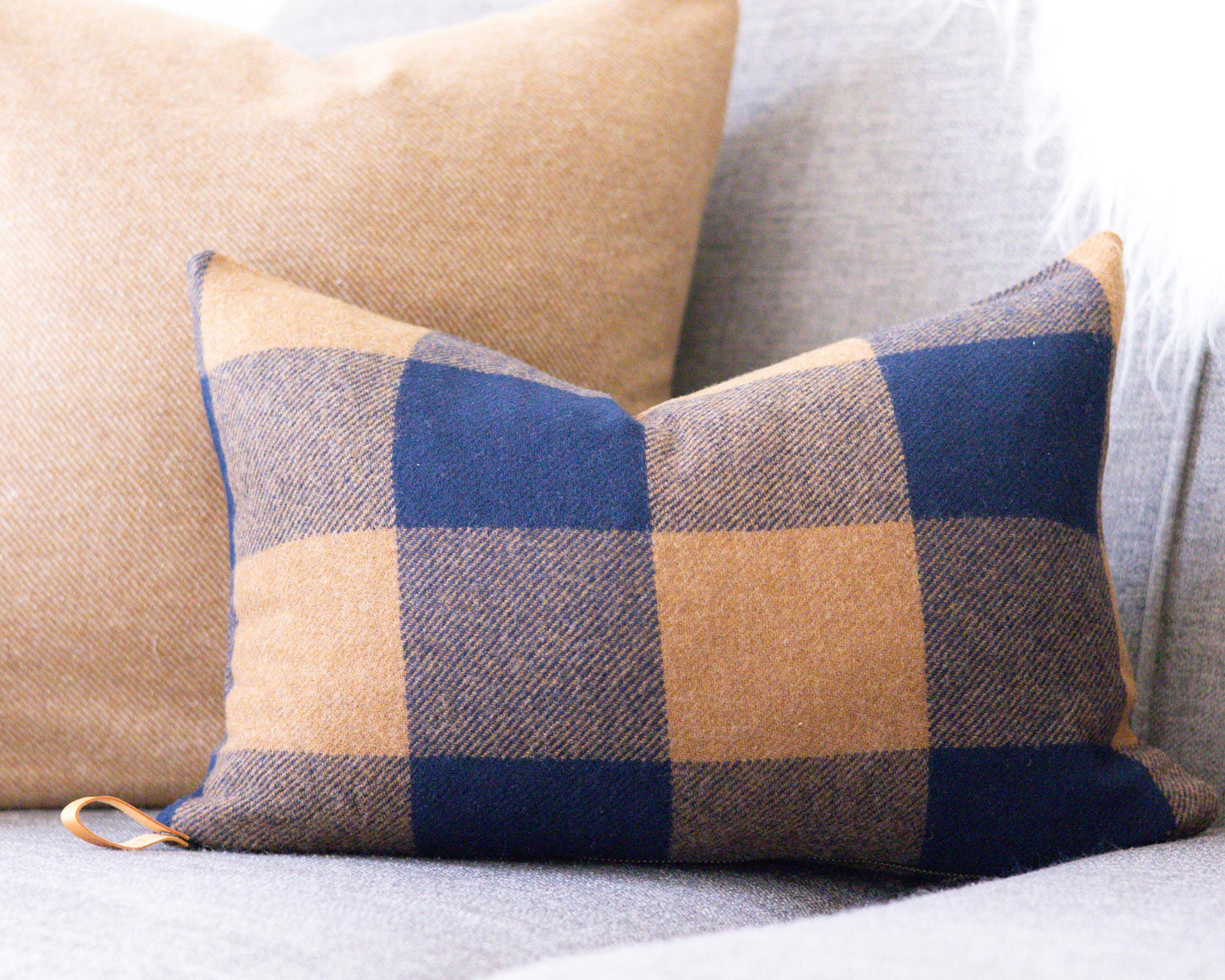 Plaid pillow on a sofa with a neutral background