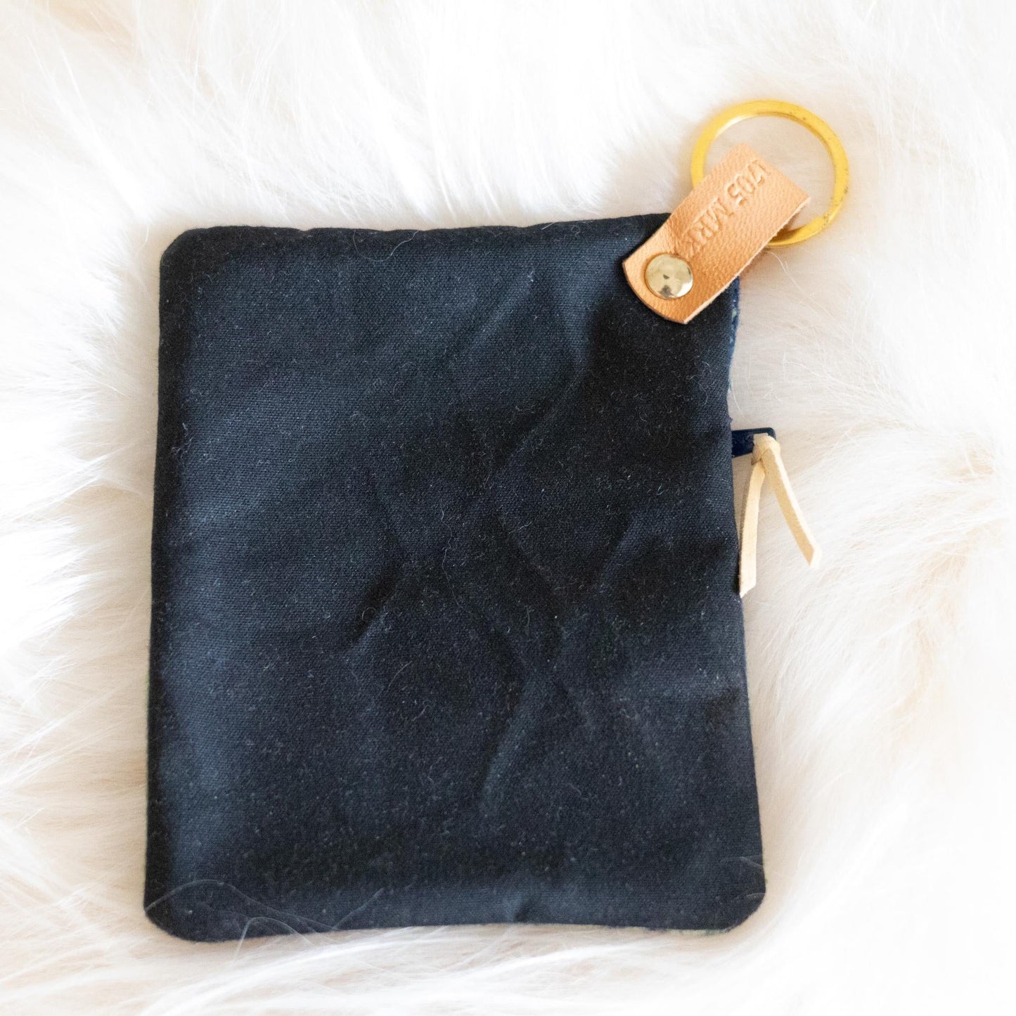 Black pouch with a gold zipper and keychain on a white background