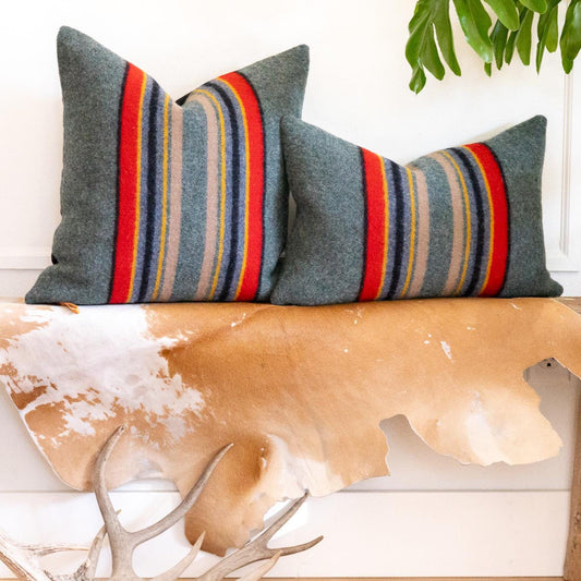 Decorative pillows with striped pattern on a wooden surface
