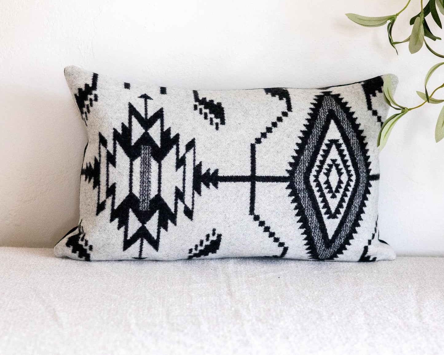 Decorative pillow with black geometric pattern on a white couch