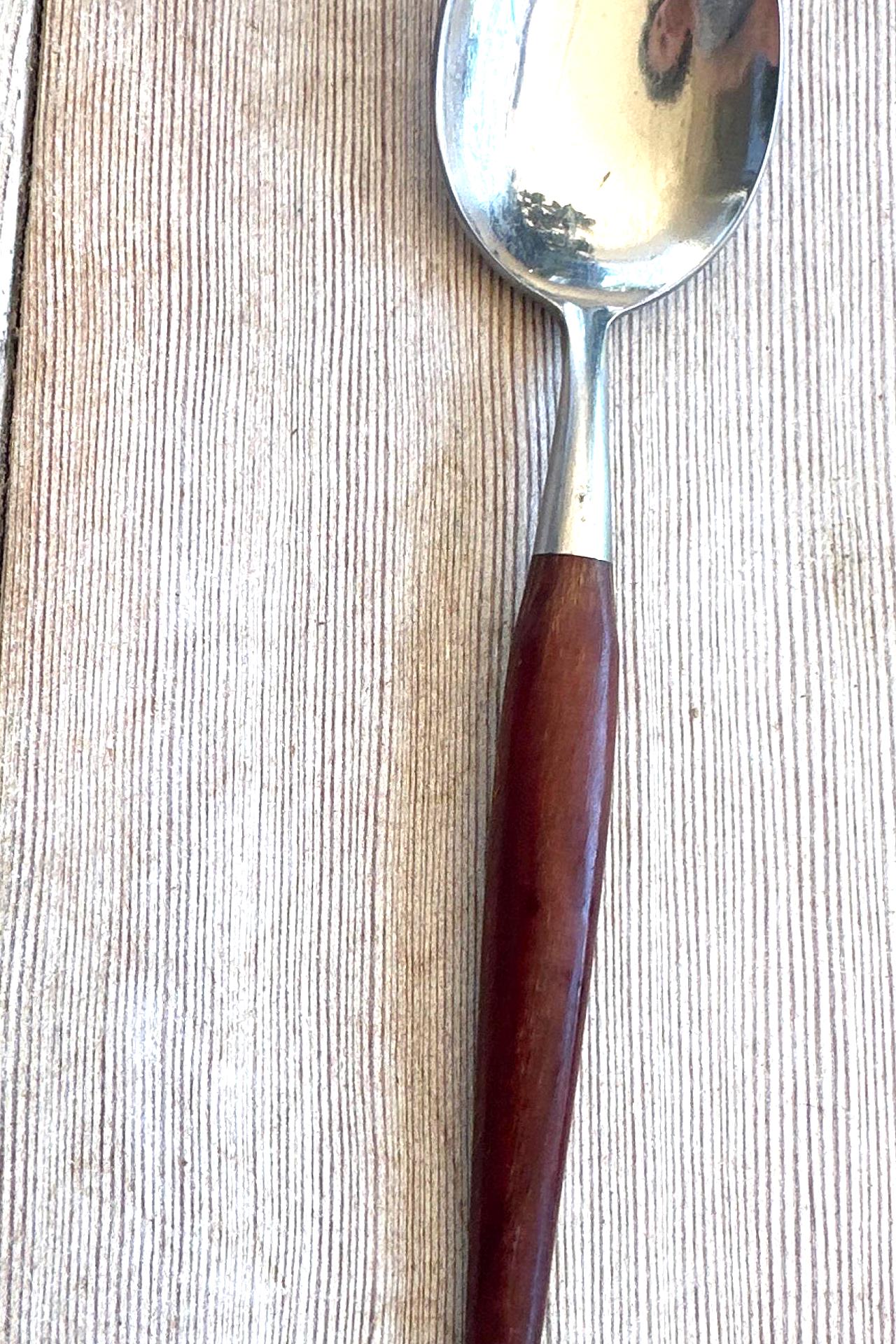 Spoon with a wooden handle on a wooden surface