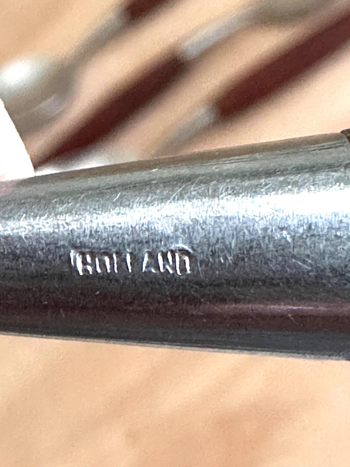 Metal rod with 'Holland' branding on a blurred background