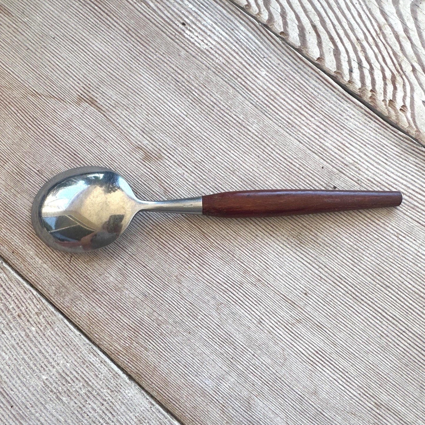 Spoon with a wooden handle on a wooden surface