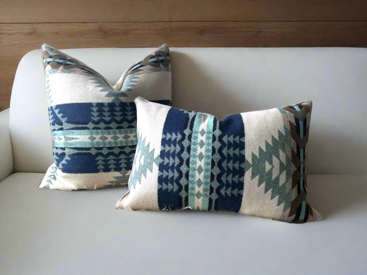 Two patterned pillows on a textured surface with a neutral background