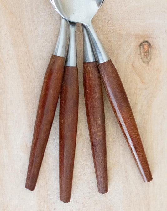 Three spoons with wooden handles on a wooden surface