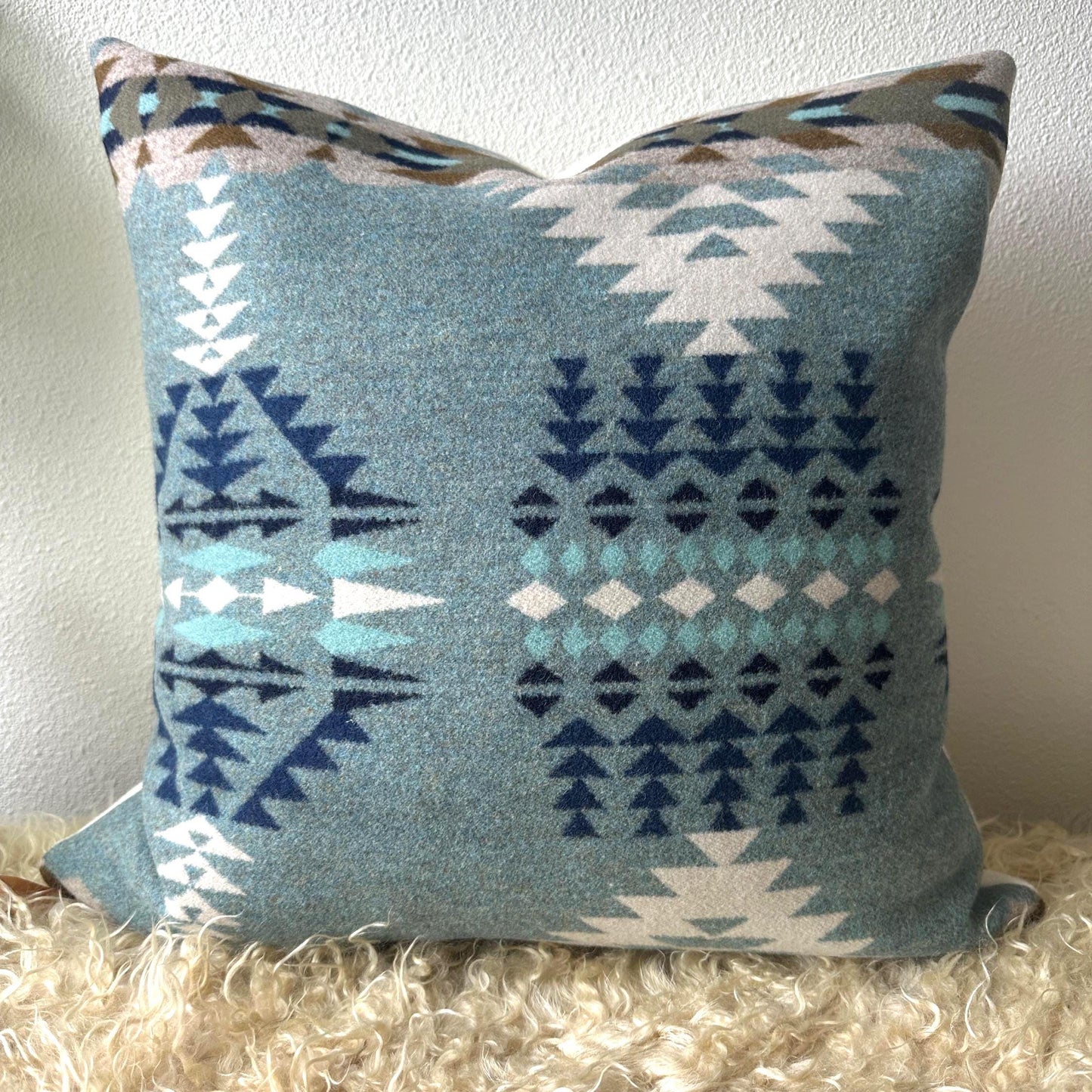 Decorative pillow with geometric pattern on a textured surface