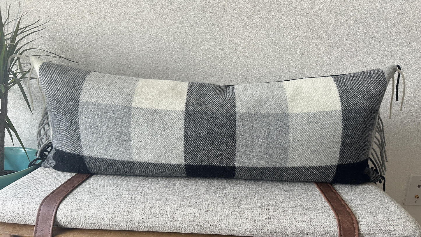 Long plaid pillow on a sofa with a neutral background