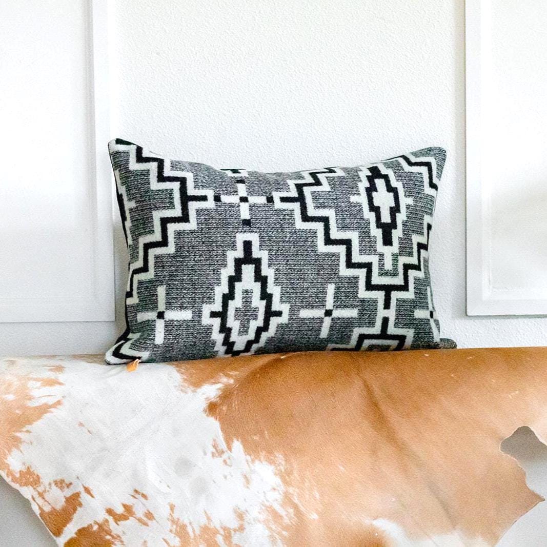 Decorative pillow with geometric pattern on a wooden surface