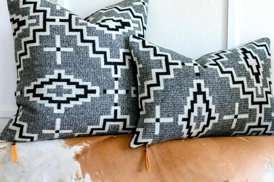 Two decorative pillows with geometric patterns on a couch.