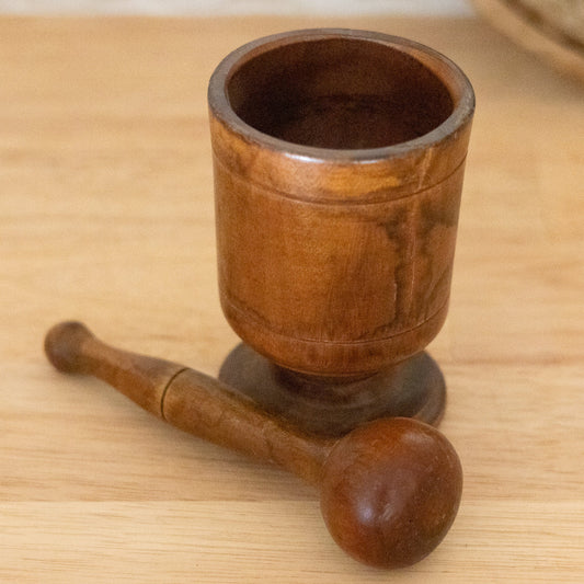 Wooden mortar and pestle on a wooden surface