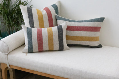 Striped cushions on a white sofa with a plant in the background