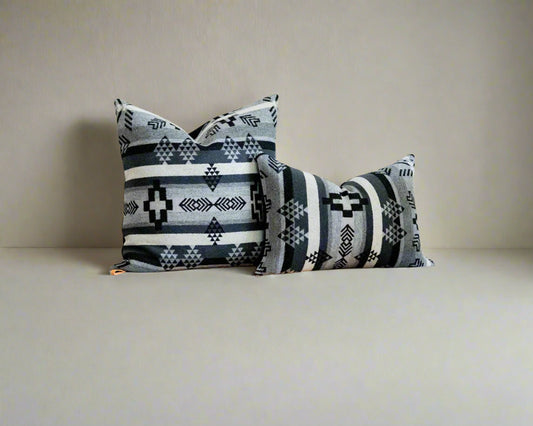 Decorative pillows with southwestern patterns on a soft gray background