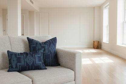Two blue patterned pillows on a gray couch.