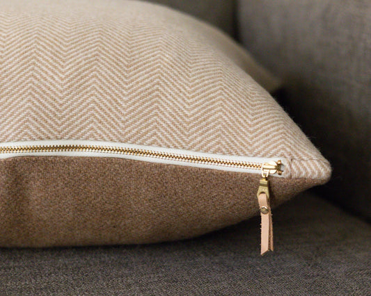 Beige cushion with a zipper on a gray sofa