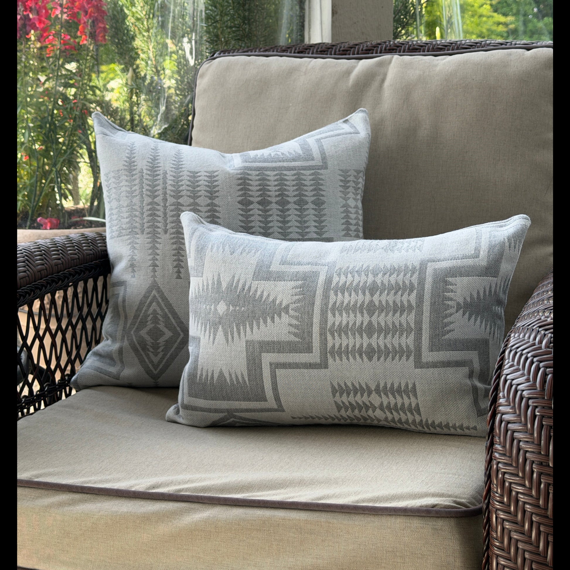 Patterned cushions on a wicker chair with a blurred outdoor background