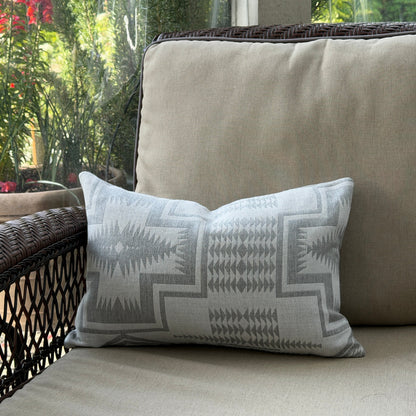 Decorative pillow with geometric pattern on a beige cushion outdoors.