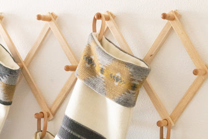Decorative stockings with striped patterns hanging on a wooden rack.