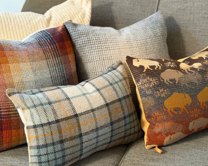 Merced and Misty Ridge plaid pillow styled with plaid and bison print pillows on a gray sofa