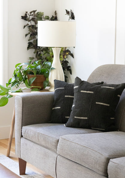 Gray sofa with black patterned pillows in a living room setting.