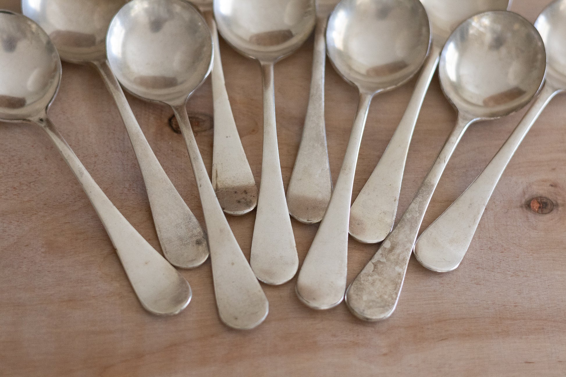 Set of silver spoons on a wooden surface