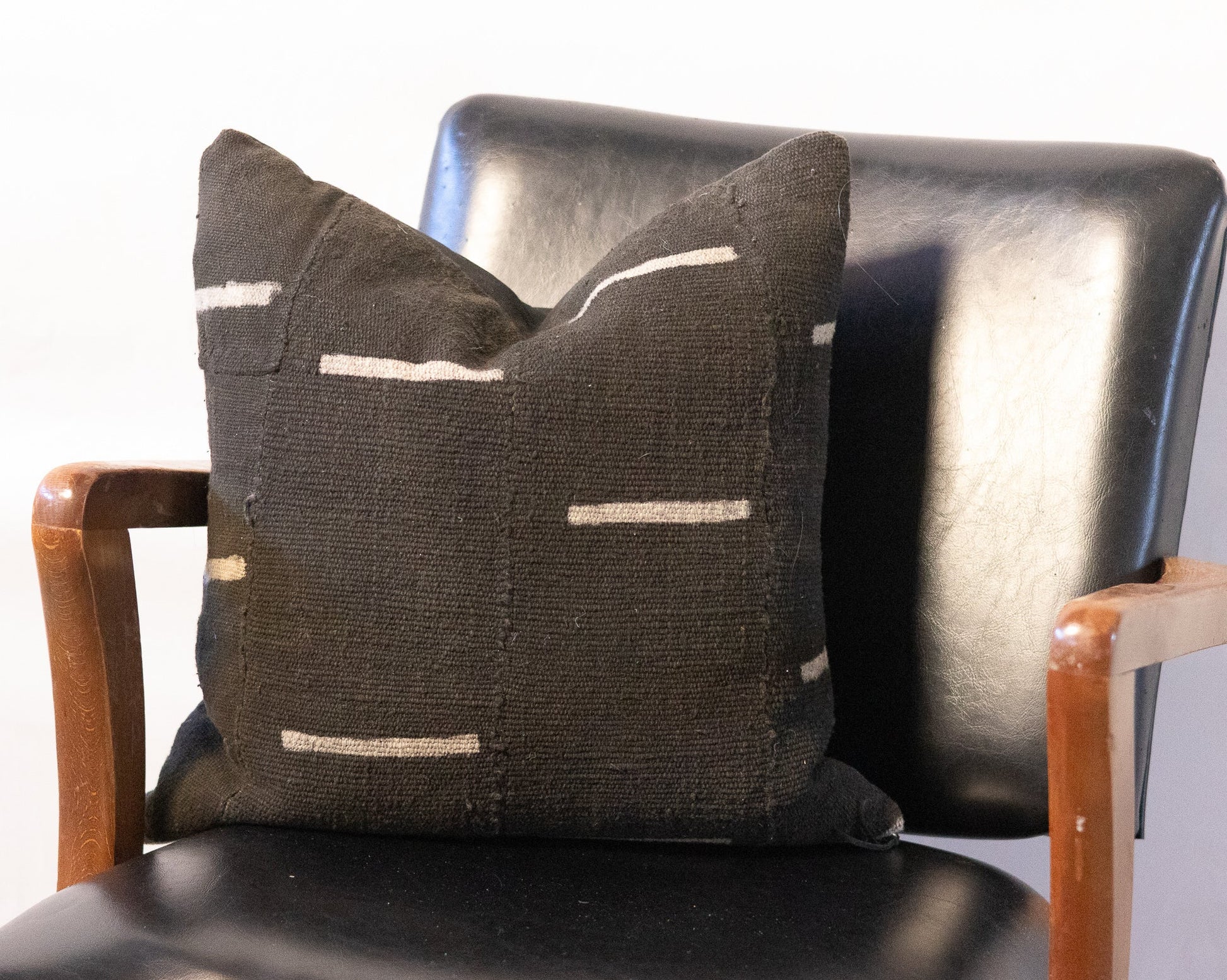 Decorative pillow with geometric pattern on a black chair