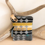 Small pouch with geometric pattern on a wooden surface with antlers