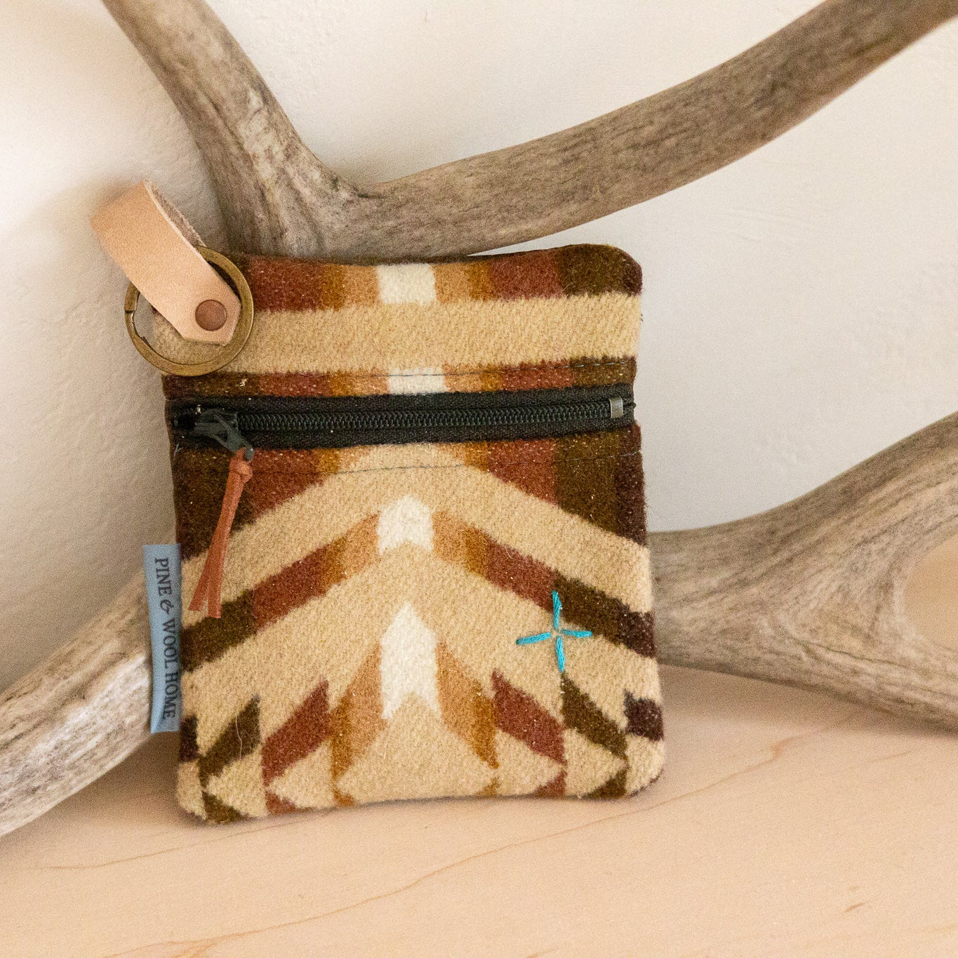 Small pouch with a geometric pattern on a surface with antlers in the background