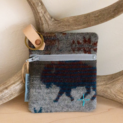 Small pouch with a buffalo design on a wooden surface with antlers
