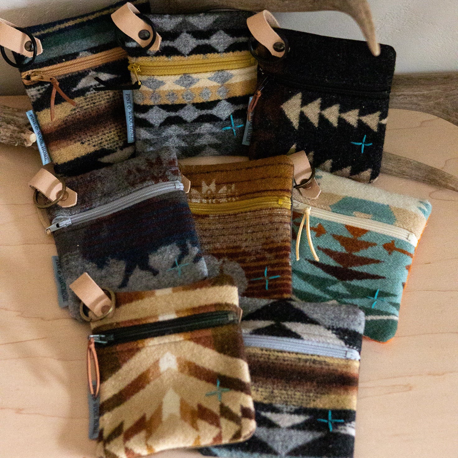 Collection of patterned pouches on a wooden surface with driftwood in the background