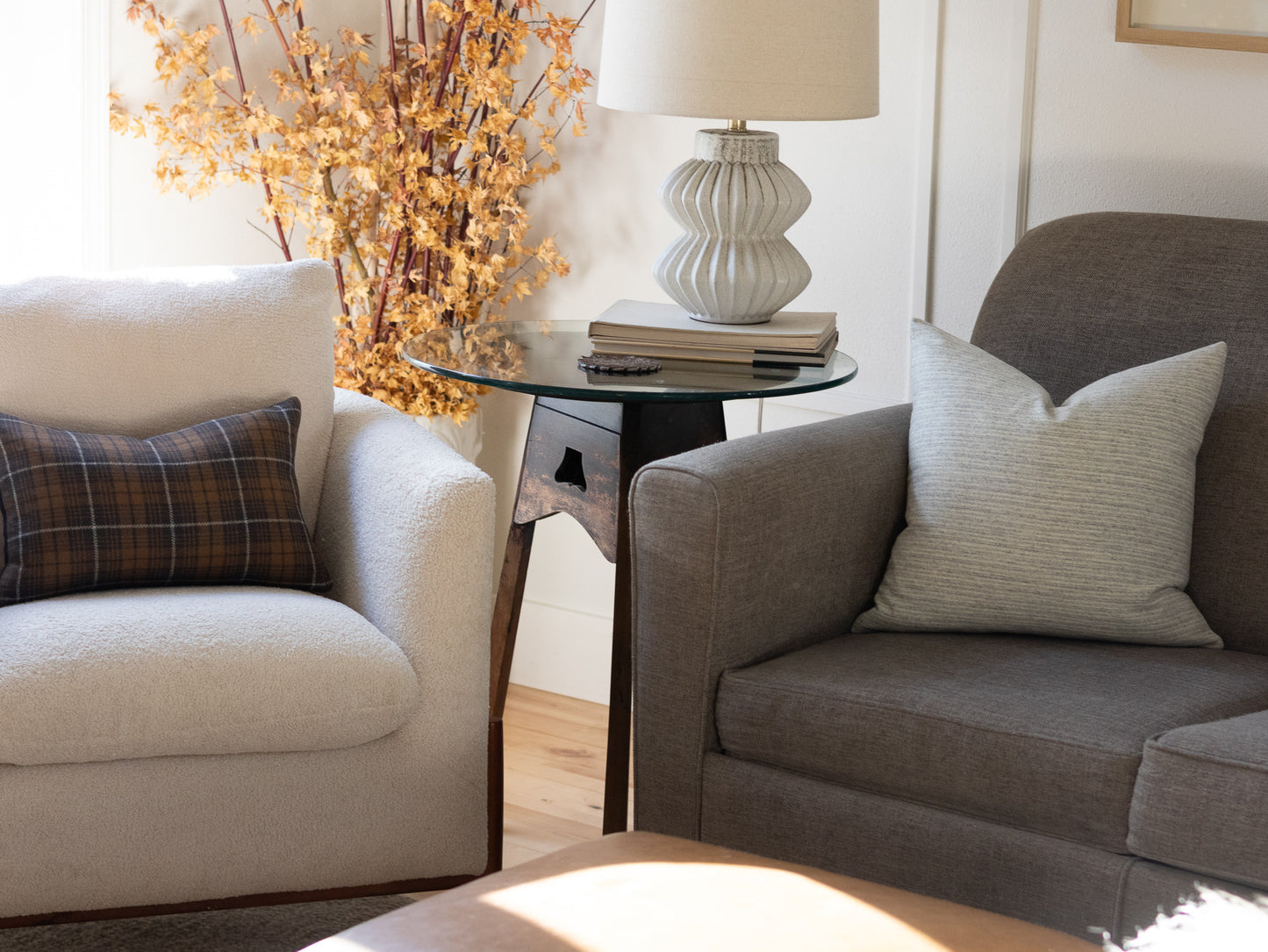 Neutral stripe wool pillows and charcoal plaid lumbar pillow styled on accent chairs in living room