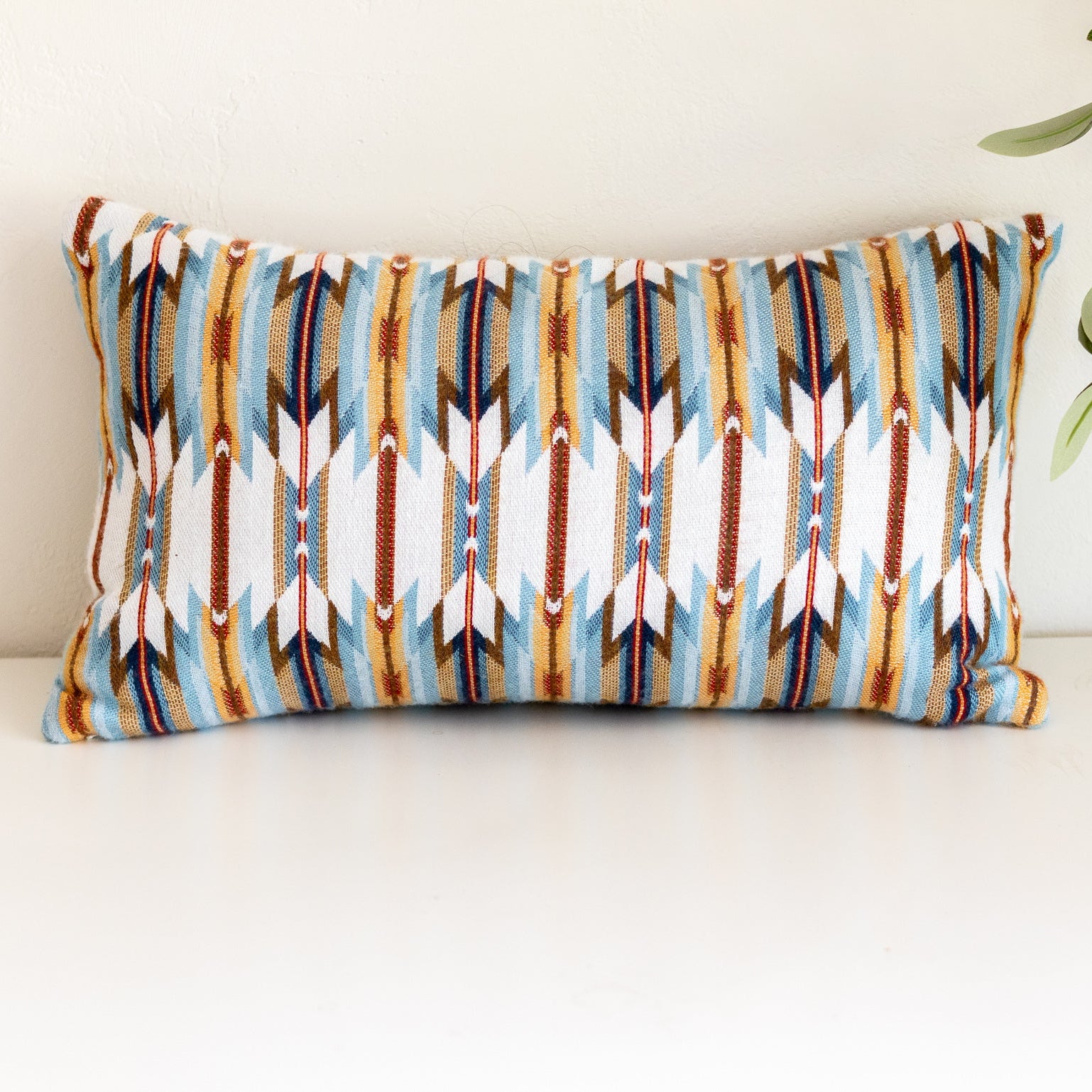 Decorative pillow with tribal pattern on a white surface