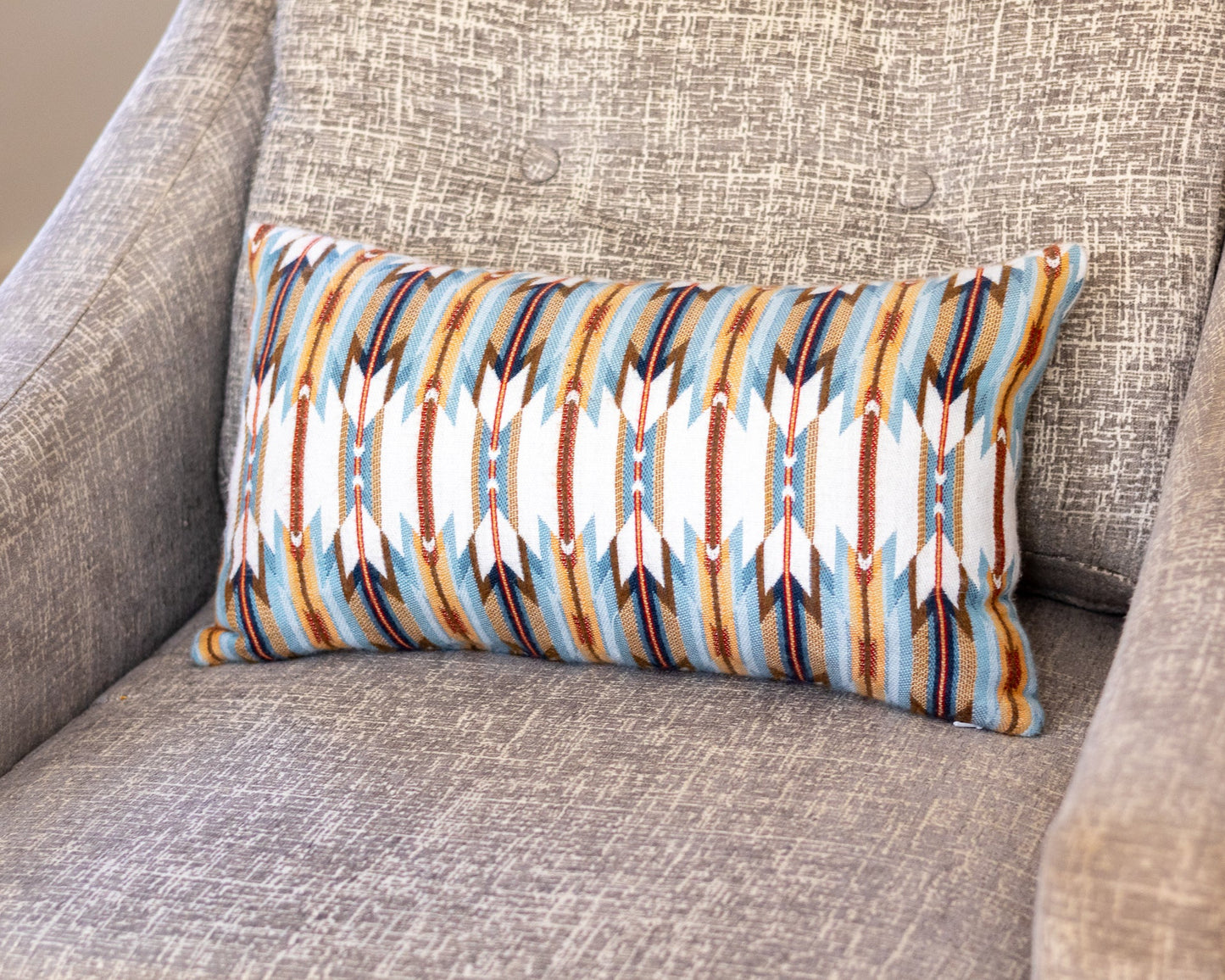 Decorative pillow with geometric pattern on a gray sofa