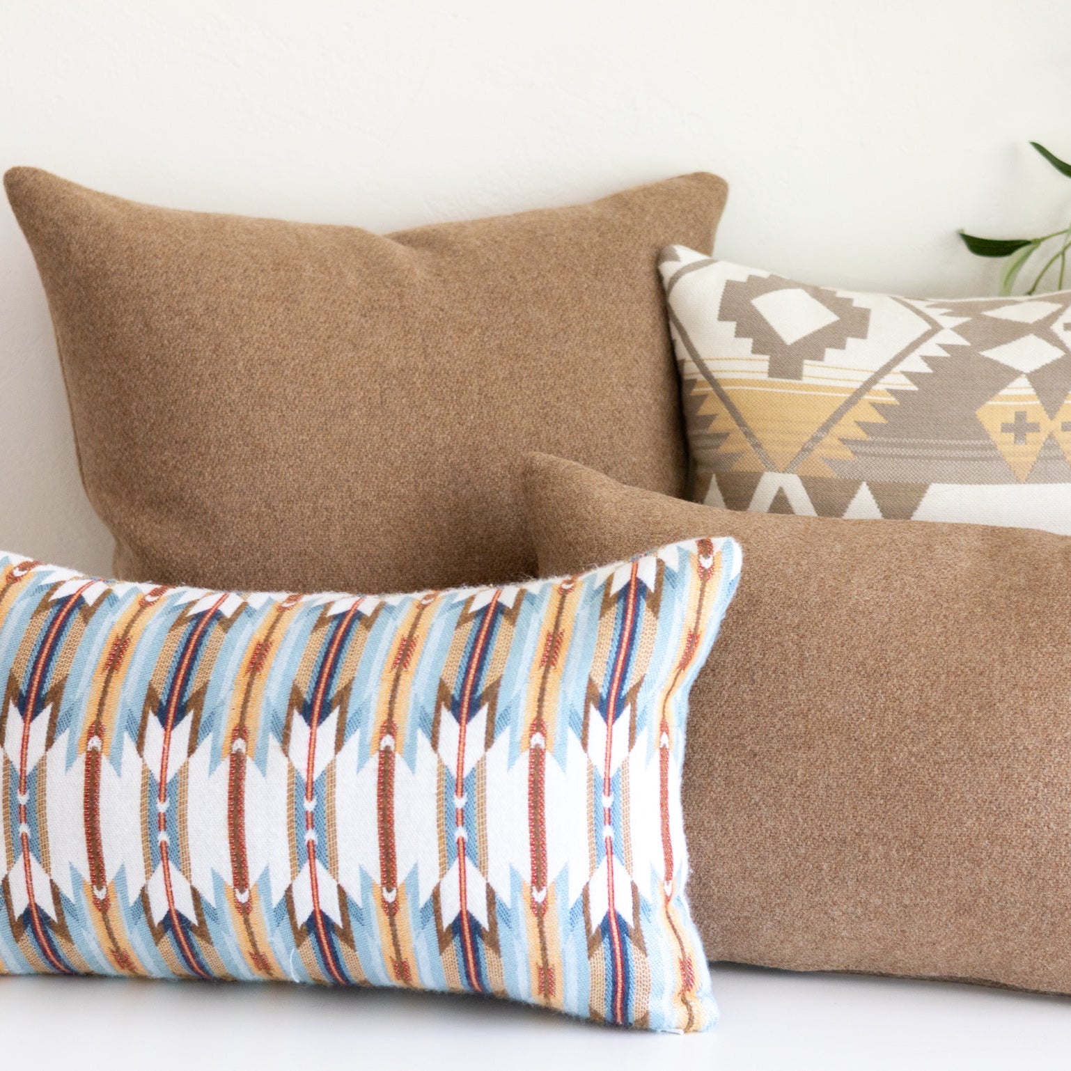 Decorative pillows with tribal patterns on a white surface.