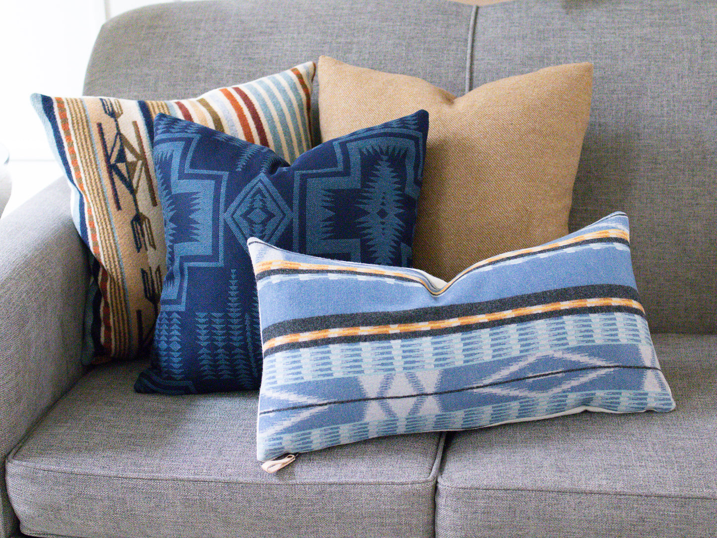 Decorative pillows with geometric patterns on a gray sofa