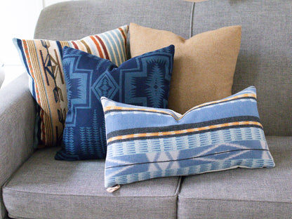 Decorative pillows with geometric patterns on a gray sofa