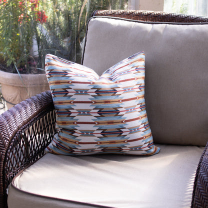 Decorative pillow with tribal pattern on a wicker chair outdoors