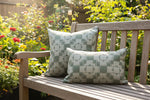 two patterned pillows on a bench in a sunny backyard