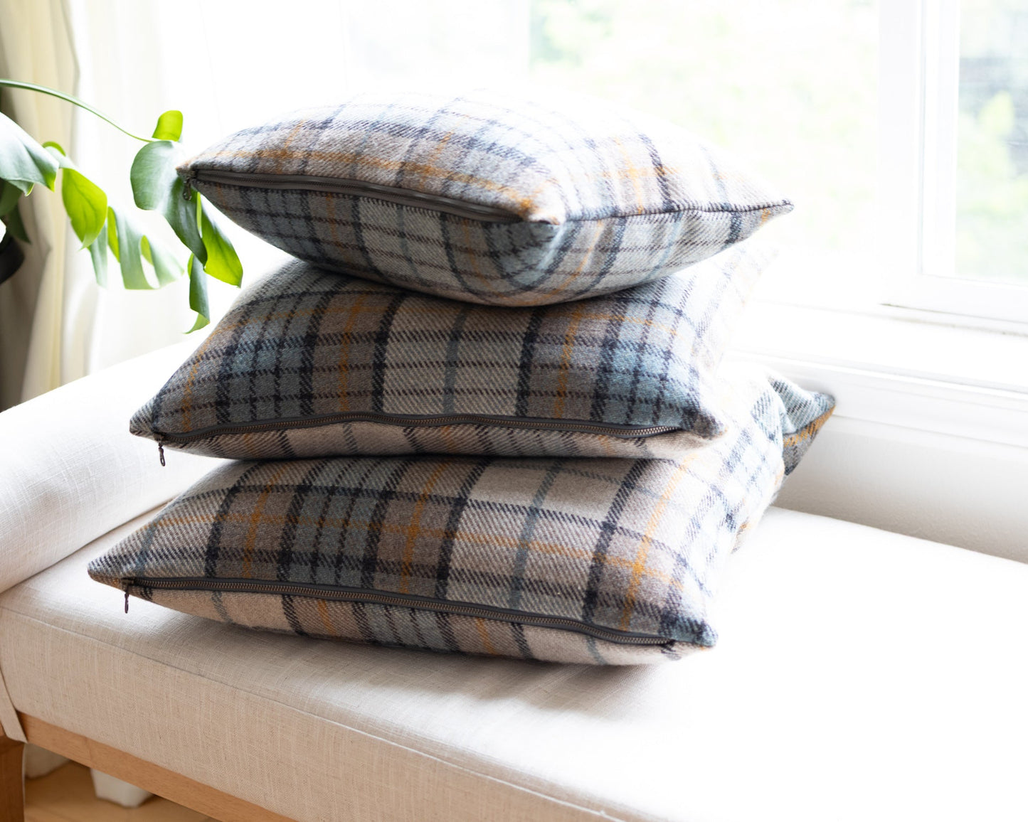 Stack of plaid cushions on a white sofa with a blurred background