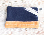 Fabric pouch with blue, white, and orange pattern on a wooden surface