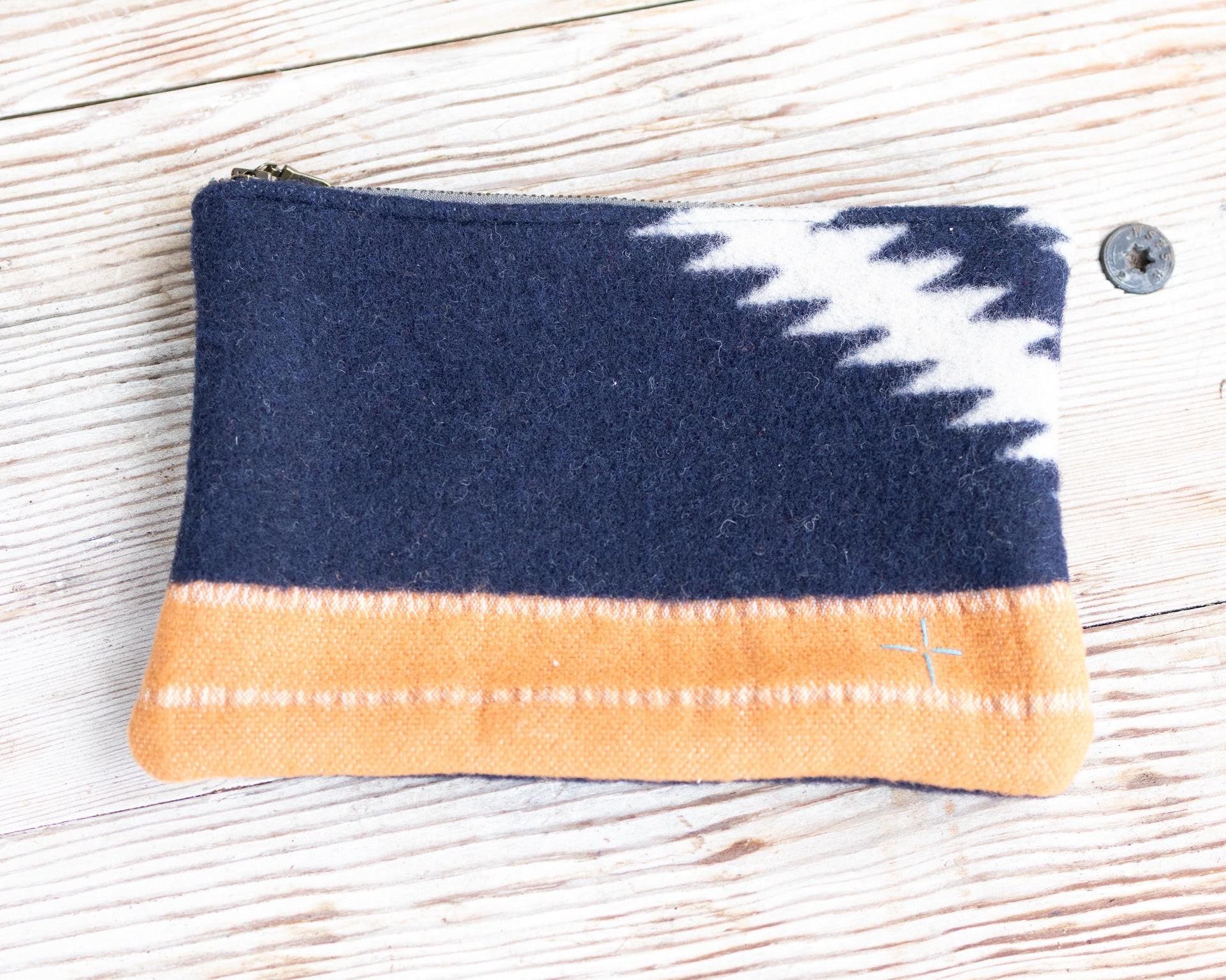 Fabric pouch with blue, white, and orange pattern on a wooden surface