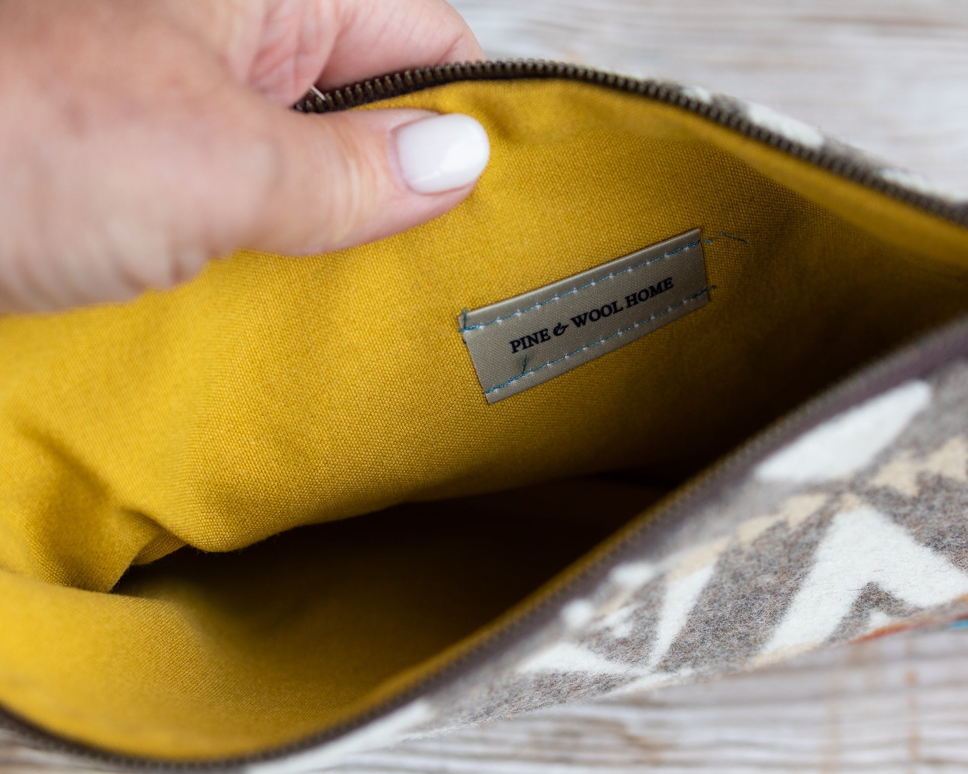 Yellow pouch with a brand label being held by a hand.