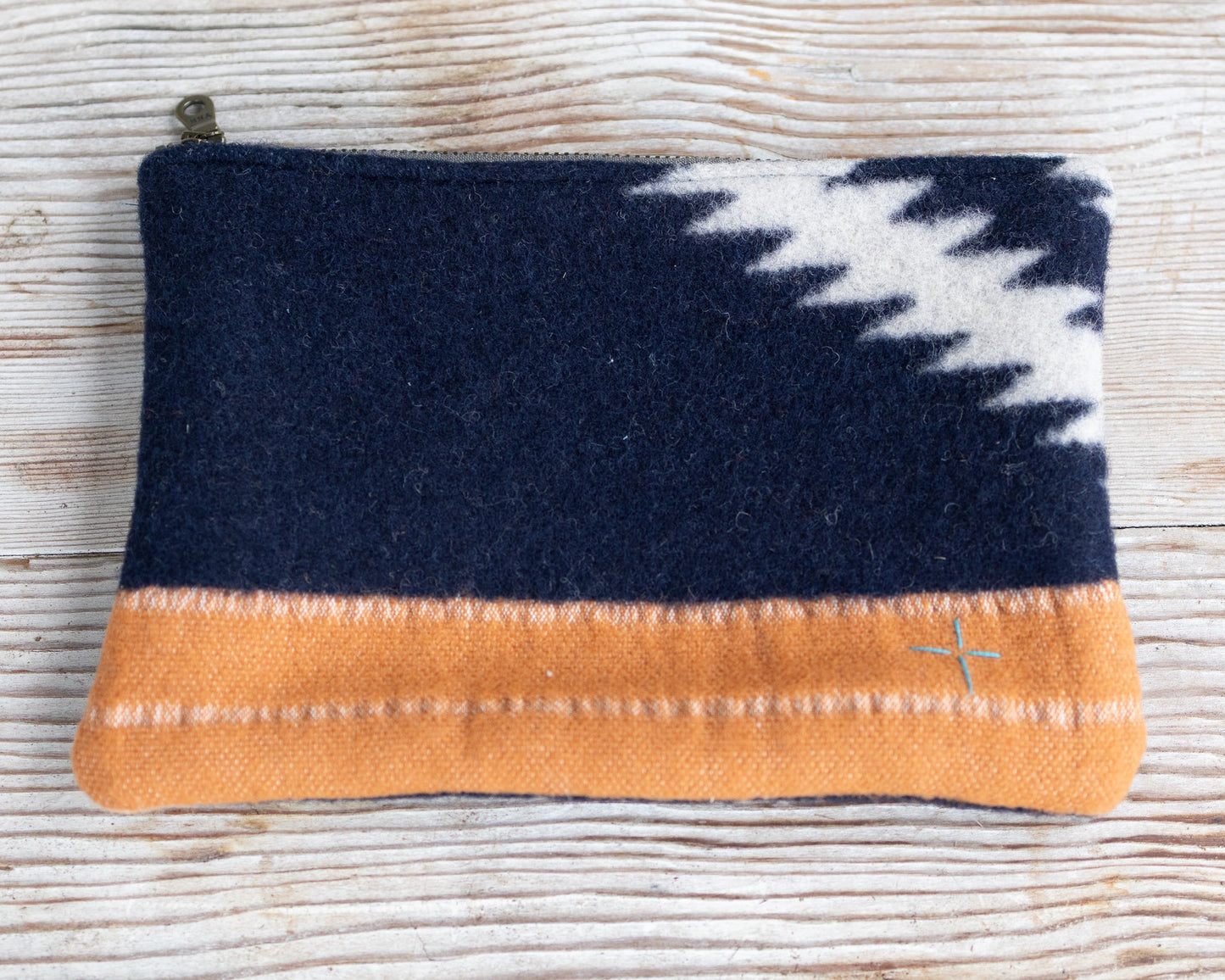 Navy and orange pouch with a white pattern on a textured surface