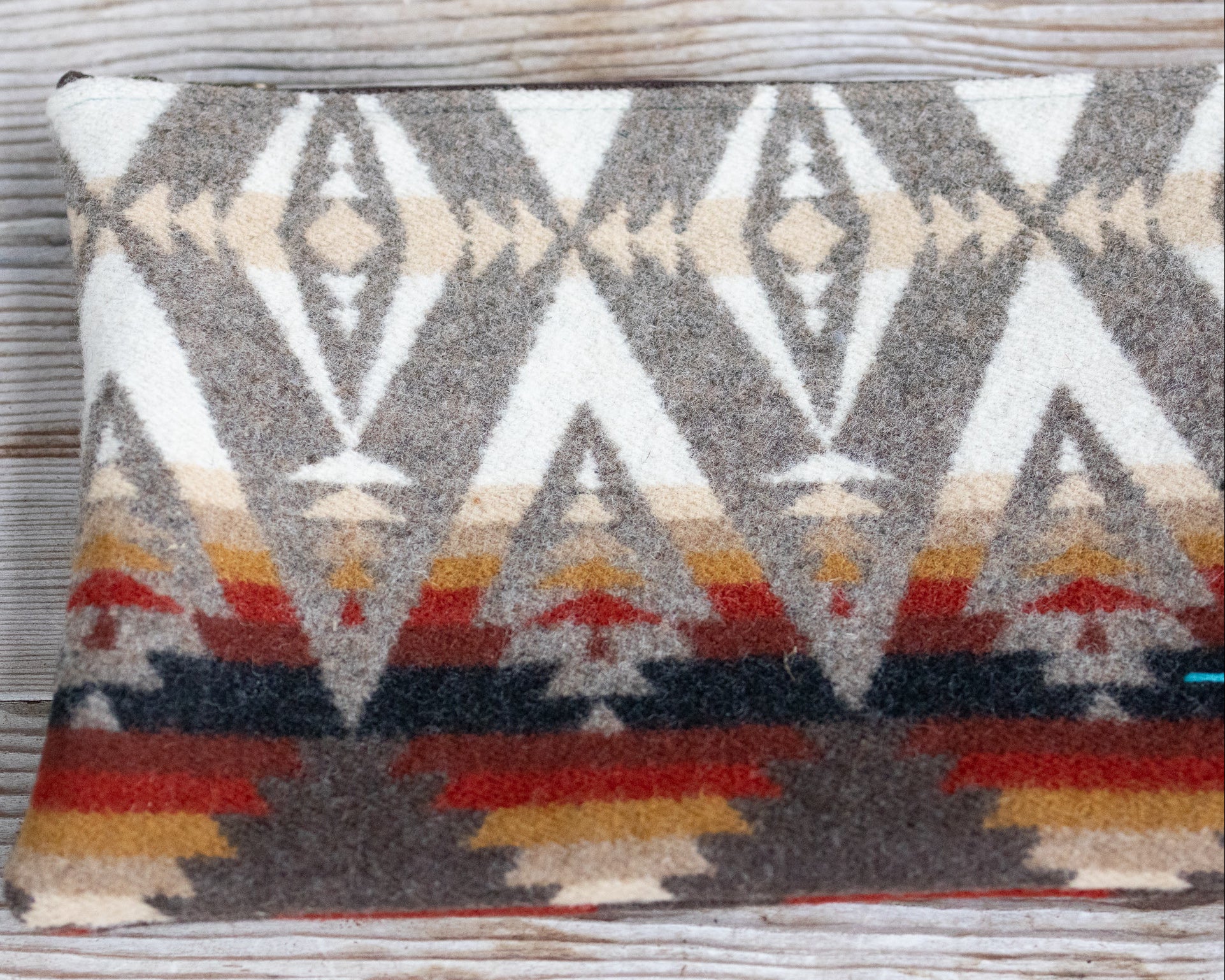 Decorative pillow with geometric pattern on a wooden surface