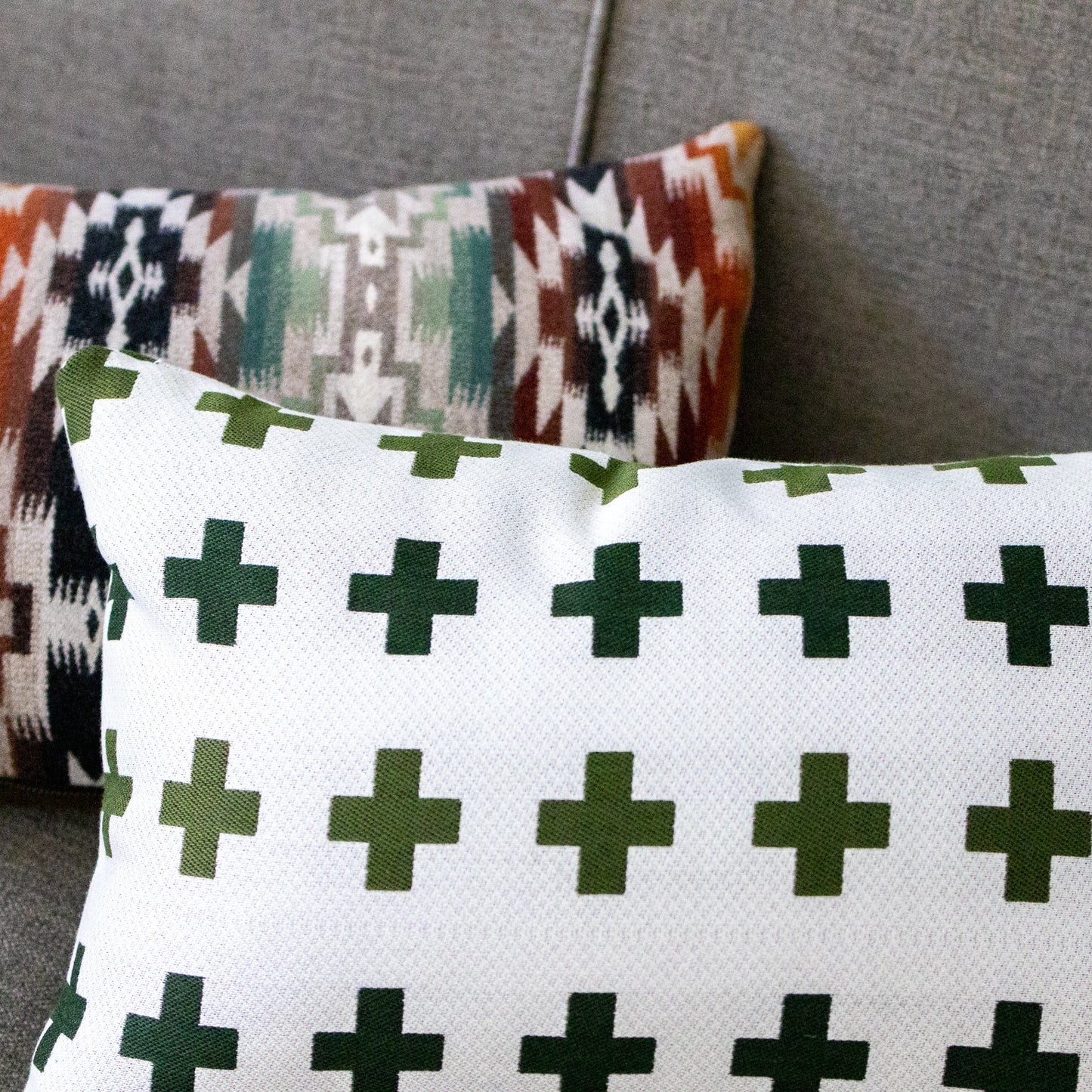 Two patterned pillows on a gray surface