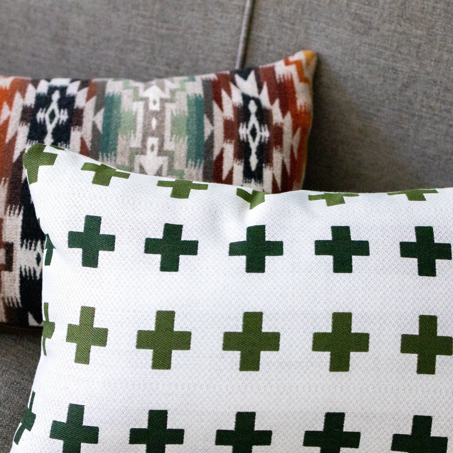 Two patterned pillows on a gray surface