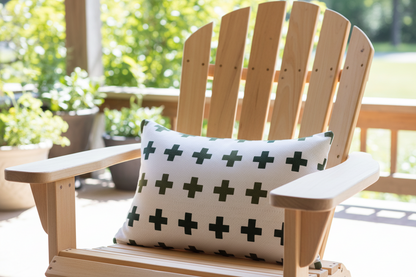 White pillow with black cross pattern on a metal chair