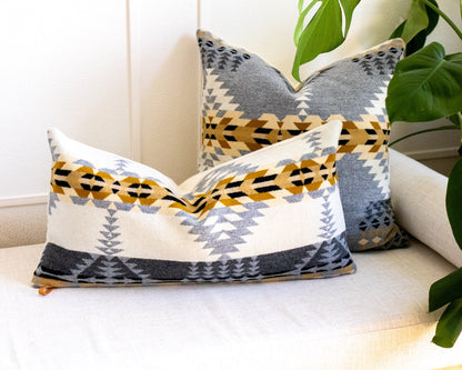 Decorative pillows with geometric patterns on a white couch