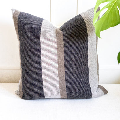 Striped pillow on a white couch with a plant in the background