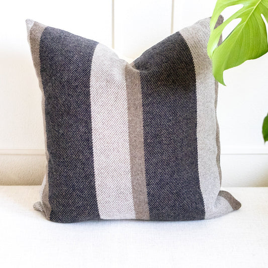 Striped pillow on a white couch with a plant in the background