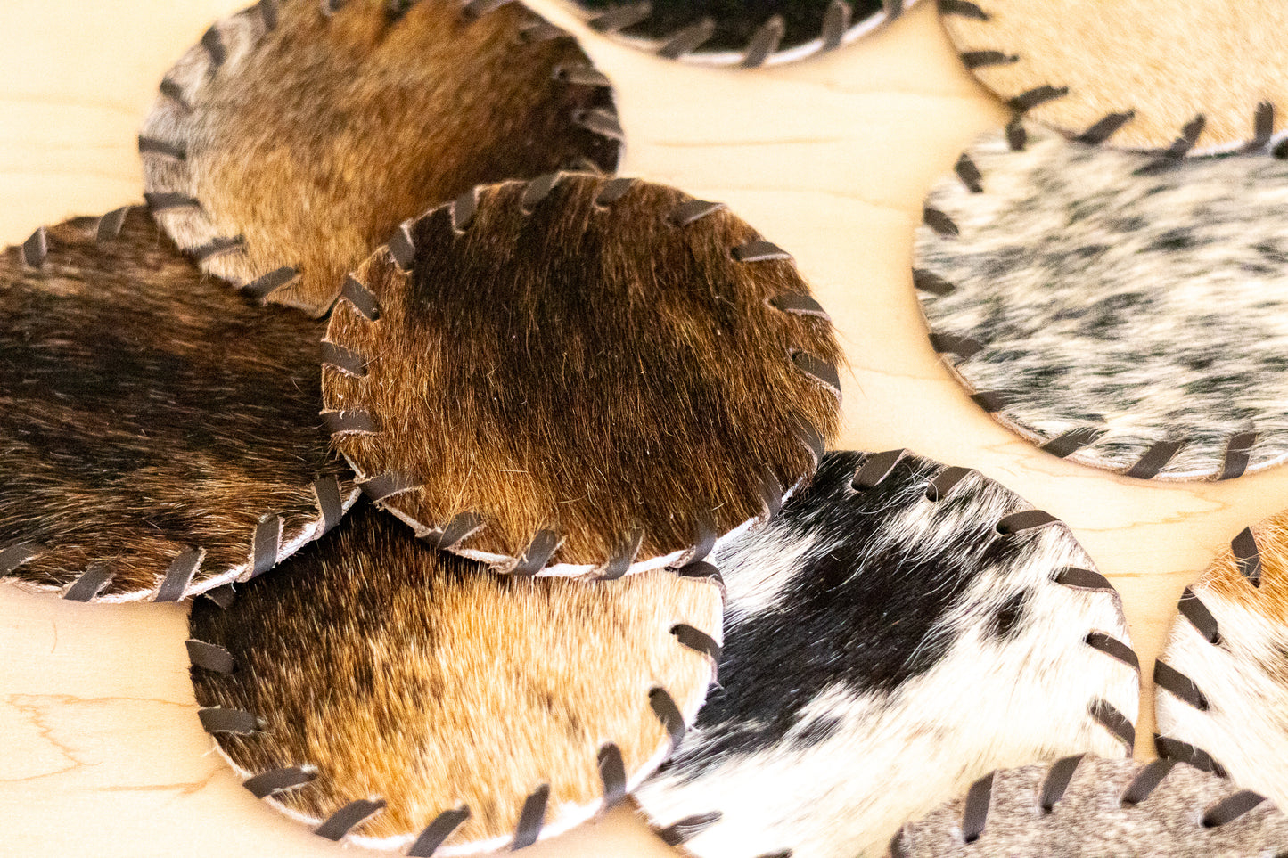 Close-up of cowhide leather coasters with different patterns